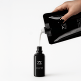 Black Oud Beard Oil drops on hand — non-greasy beard oil for growth