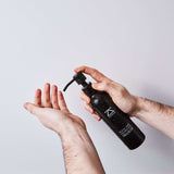 Man holding ZOUSZ Black Oud Beard Shampoo — small-batch British men's grooming