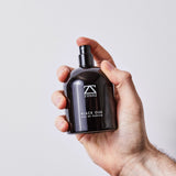 Man holding ZOUSZ Black Oud Eau de Parfum — luxury British men's fragrance